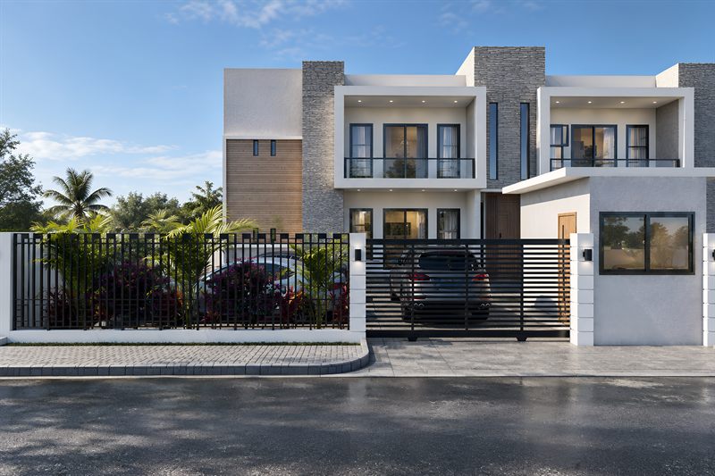 The block from the street: a sliding slatted gate with a car behind it, stone cladding and a timber panel on the wall above, balconies on the upper floor, the guard house to the right, and palms and bougainvillea behind the railings.