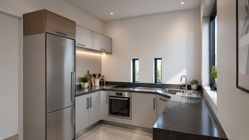 The kitchen: pale units in a U under dark stone worktops, an oven and hob on the near run, the sink below two windows, and a tall fridge at the entrance.