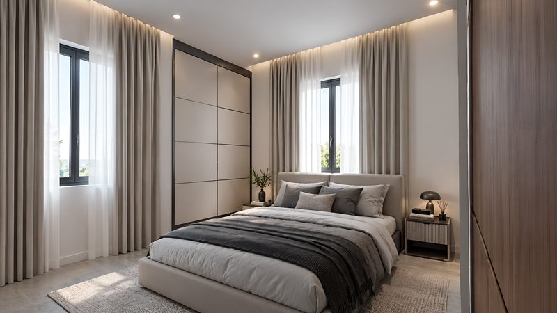 A bedroom: a double bed with an upholstered headboard between two curtained windows, a fitted wardrobe the height of the wall, and a bedside table with a lamp.
