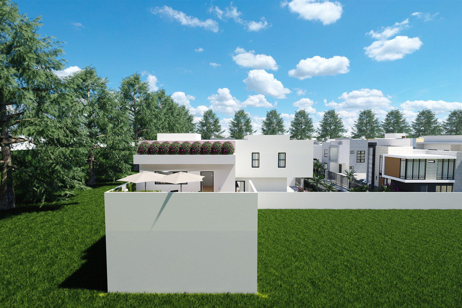The estate from the open ground along its left side, over a white boundary wall, with climbers over the roof parapet and parasols on the nearest house and the rest of the development stepping away to the right.