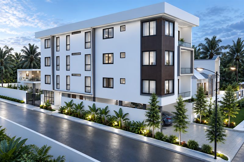 St. Luke Apartment from the road: four floors in white render, three of flats over a ground floor of open parking, a timber-clad bay running up the near corner and a boundary wall along the pavement.